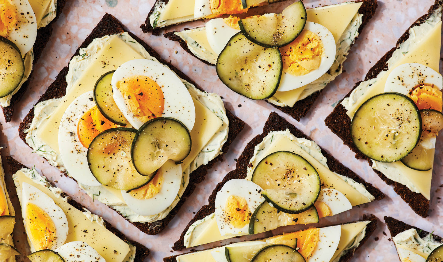 Photo of Toast topped with egg and zucchini slices on a pink surface from 'A Hearty Book of Veggie Sandwiches'