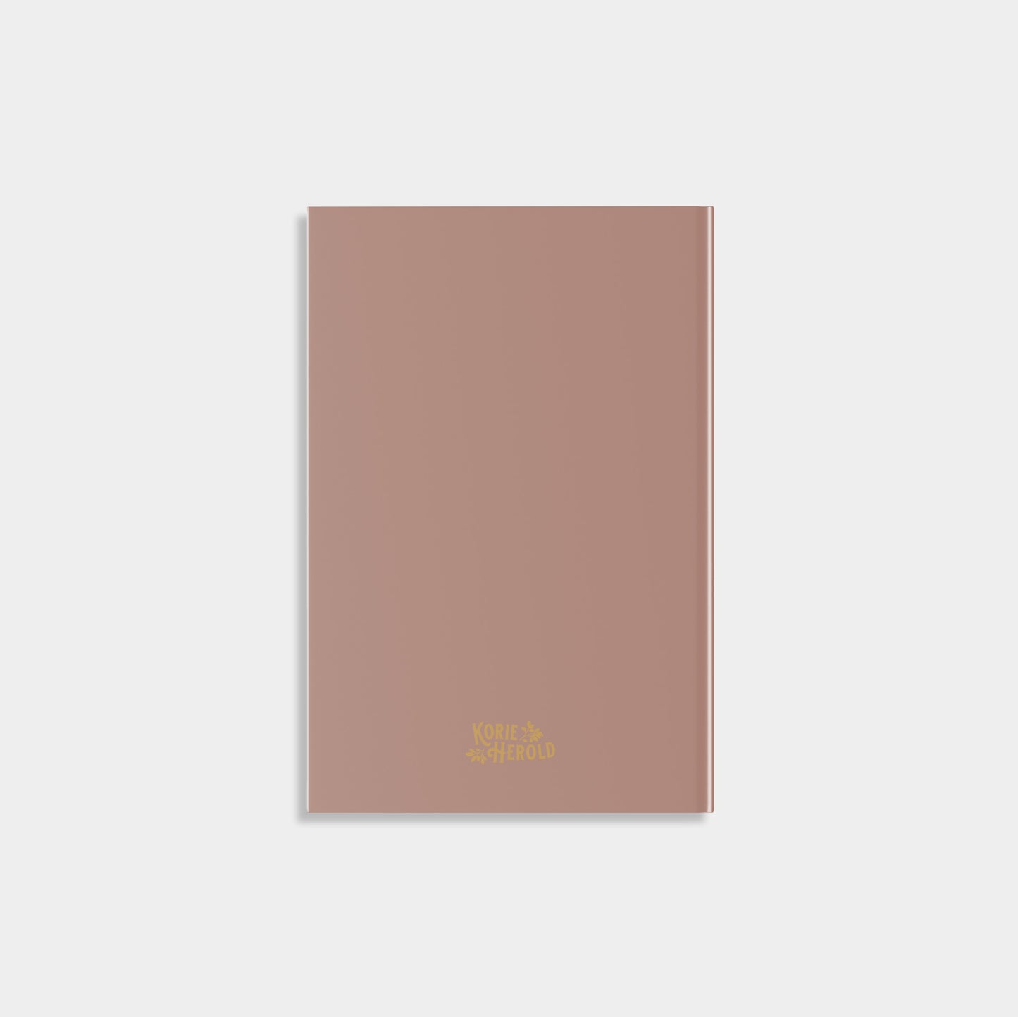 Brown notebook with gold text on a white background