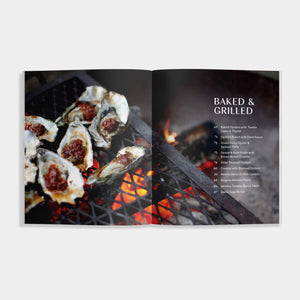 Open cookbook of 'Oysters' showing oysters being grilled over a flame with 'Baked & Grilled' text.