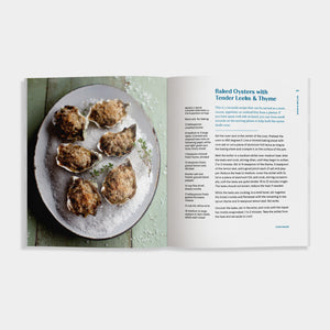 Open cookbook of 'Oysters' showing a plate of baked oysters with text on a green background