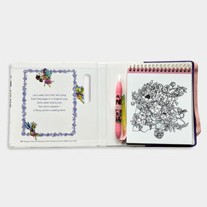 Coloring book open to a page with floral design and text, held by a hand.