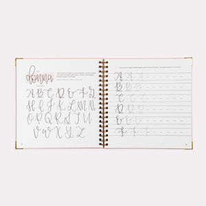 Open notebook with calligraphy practice pages on a white background