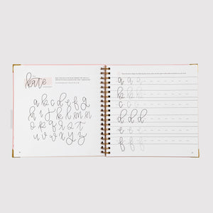 Open notebook with handwriting practice pages on a white background