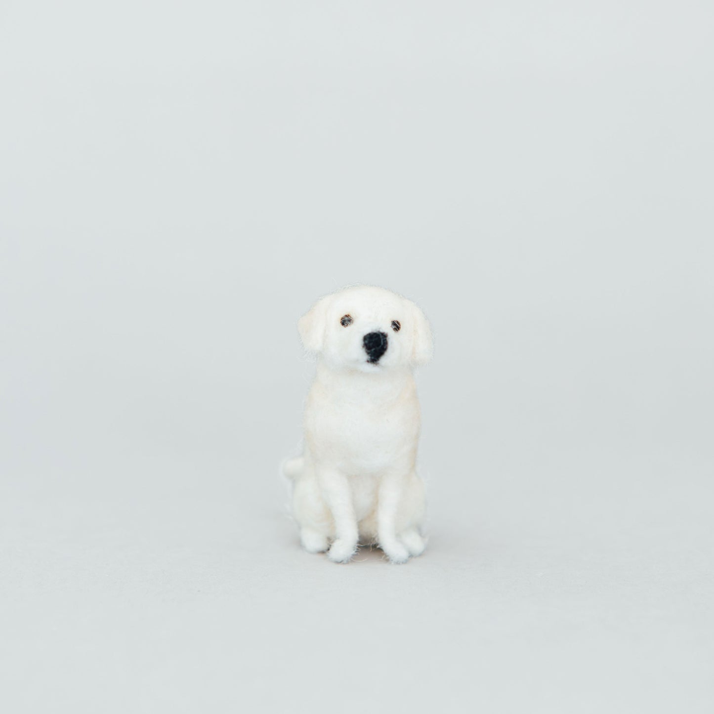 White dog figurine on a light gray background
