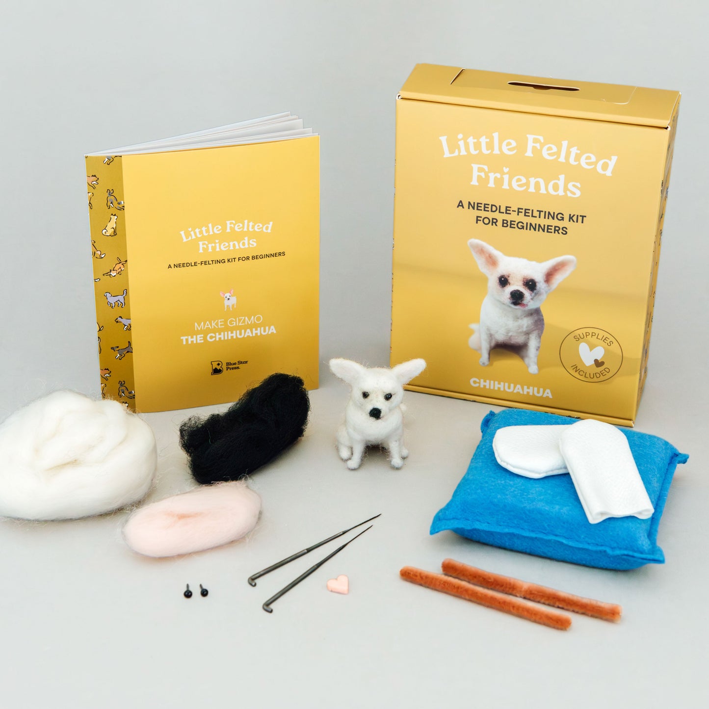 Felting kit with materials and tools on a gray background