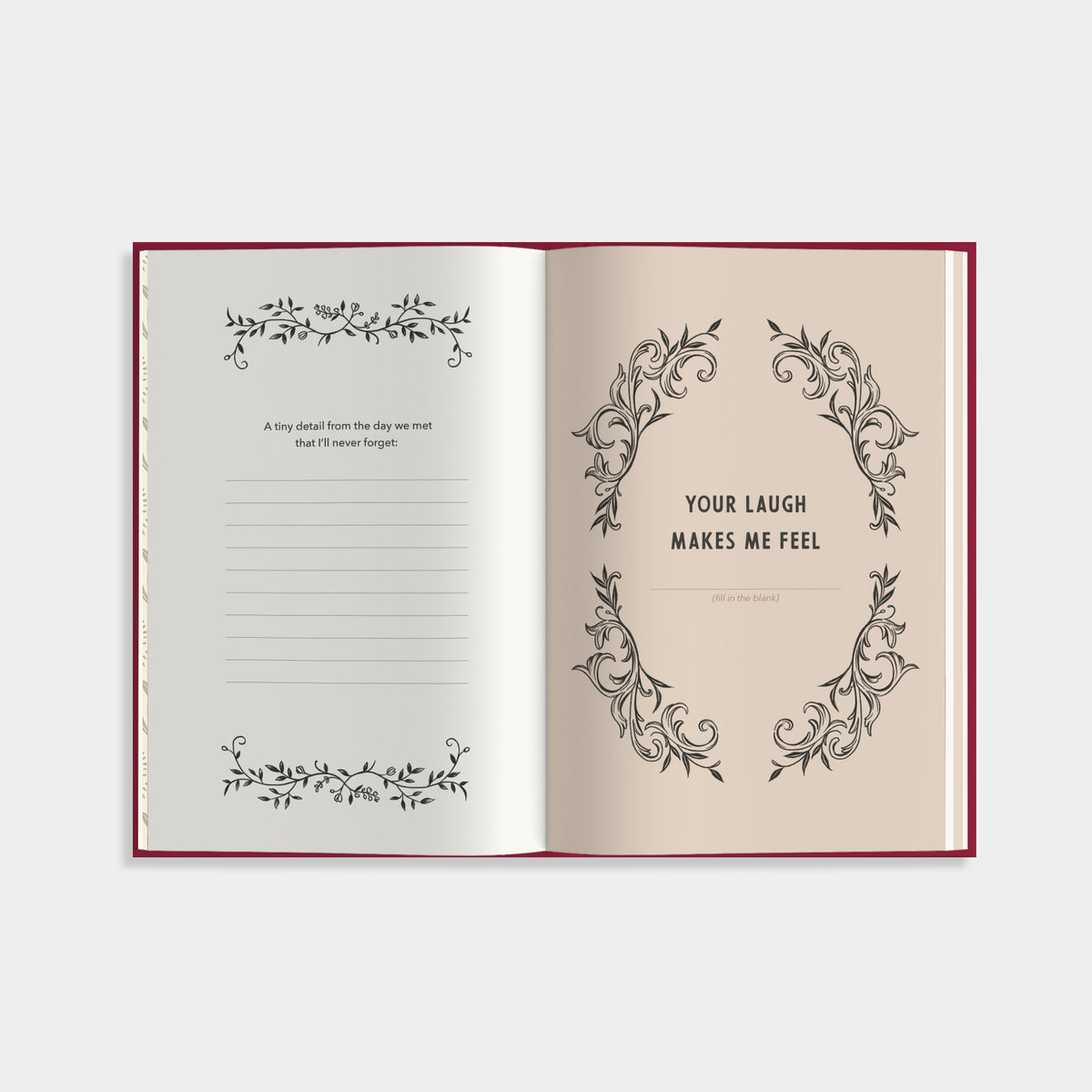 An open notebook or journal with cream pages and a burgundy border, shown against a light gray background. The left page has lined writing space with decorative black floral scroll borders at the top and bottom, and a short quote.
