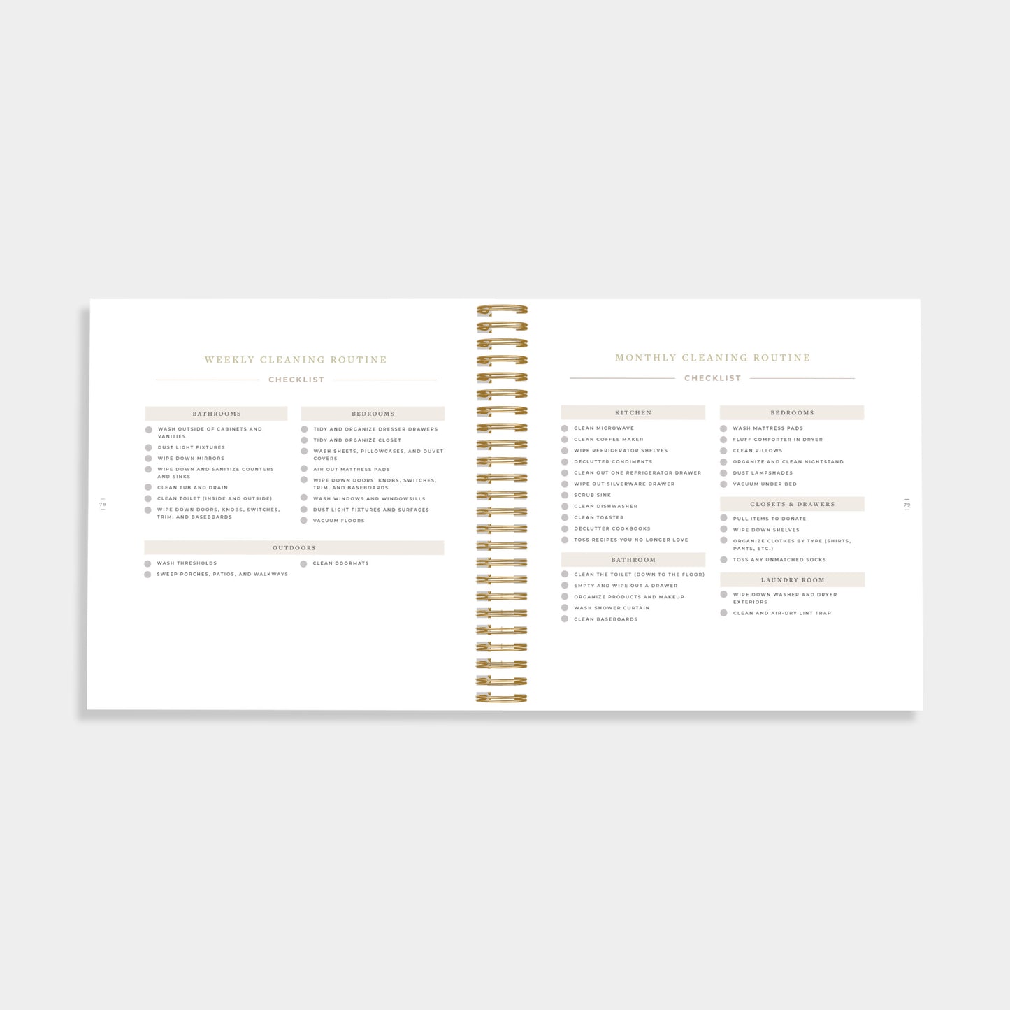 An open spiral-bound planner or notebook showing two printed pages with cleaning routine tables and headings, photographed on a light gray background.